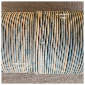 May include: Close-up of a spool of antique leather cord. The cord is a light brown color with a distressed, aged look. The text "antique leather supply" is visible on the spool.