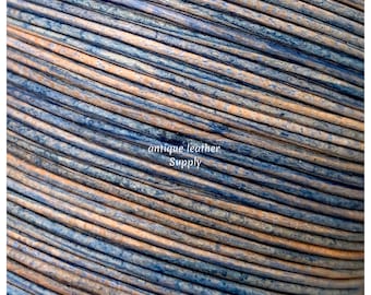 May include: Close-up of a spool of blue and brown leather cord. The cord is tightly wound and has a slightly textured surface. The text "antique leather Supply" is visible on the spool.