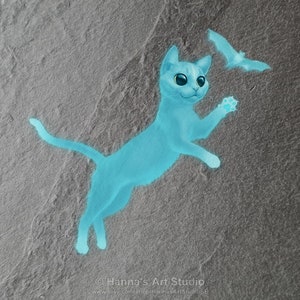 Może przedstawiać: Cyfrowa ilustracja jasnoniebieskiego kota skaczącego w kierunku nietoperza. Kot ma duże, wyraziste oczy na tle szarego tła. Grafika jest podpisana przez Hanna's Art Studio.