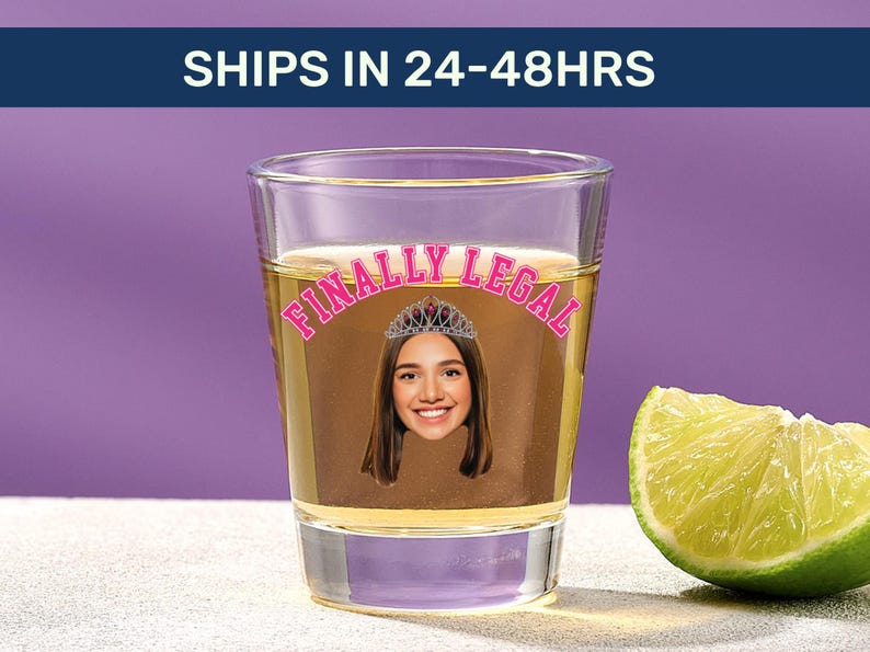 a shot glass with a picture of a girl on it next to a lime
