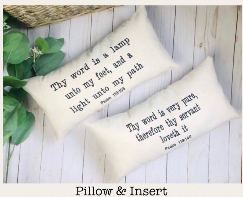 Puede incluir: Dos almohadas rectangulares de color crema con texto negro. Una almohada dice: "L&aacute;mpara es a mis pies tu palabra, y lumbrera a mi camino Salmo 119:105". La otra dice: "Mucho he amado tus mandamientos Salmo 119:140".