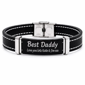 Könnte beinhalten: Ein schwarzes Lederarmband mit weißen Nähten und einer zentralen schwarzen Edelstahlplatte, die mit dem Text "Best Daddy" und "Love you lots Kate & Joe xxx" graviert ist. Das Armband hat silberfarbene Metallakzente und einen Verschluss.