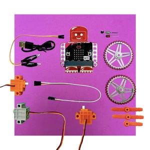 May include: A robot-shaped electronics kit with a red head and feet, a black body, and various components. Includes gears, wires, and orange and gray servo motors. The kit is designed for educational purposes.
