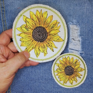 May include: Two embroidered iron-on patches featuring yellow sunflowers with brown centers on a white background. The larger patch is 4 inches in diameter and the smaller patch is 2.5 inches in diameter.