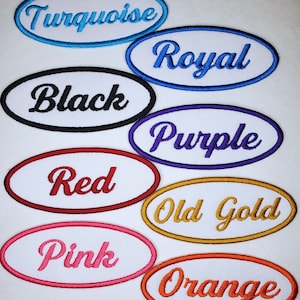 May include: Ten oval-shaped iron-on patches with white backgrounds and embroidered text in various colors. The colors include turquoise, royal blue, black, purple, red, old gold, pink, and orange. The text on the patches reads: Turquoise, Royal, Black, Purple, Red, Old Gold, Pink, and Orange.