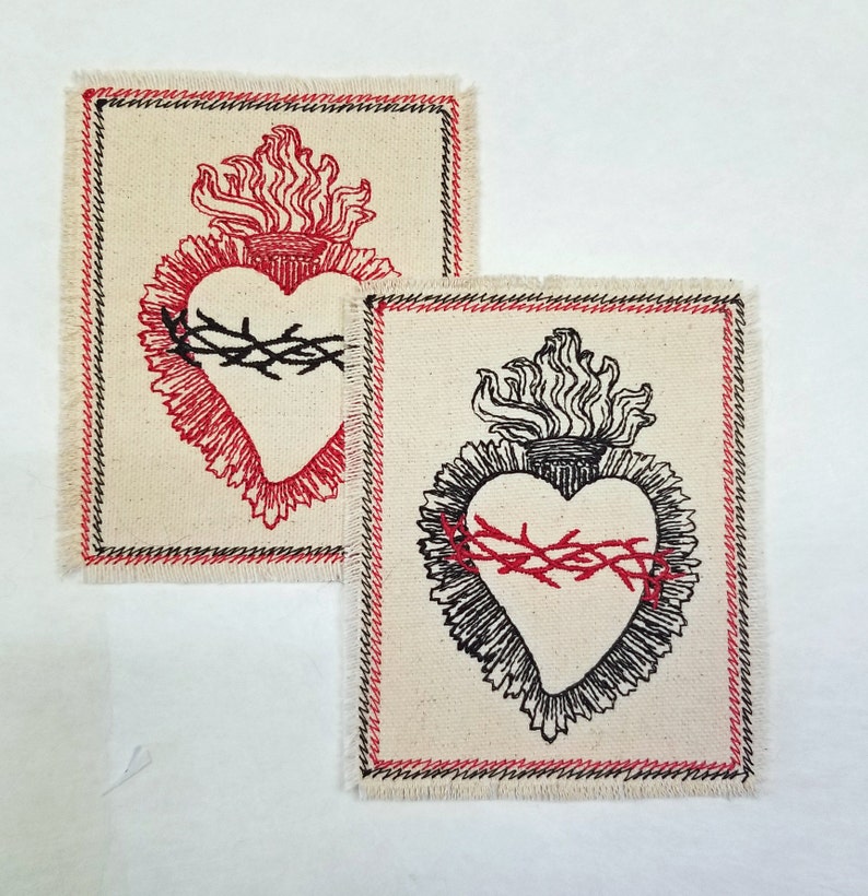 May include: Two embroidered patches with a stylized heart design. The heart is surrounded by a crown of thorns and flames. One patch is red and black, the other is black and white.