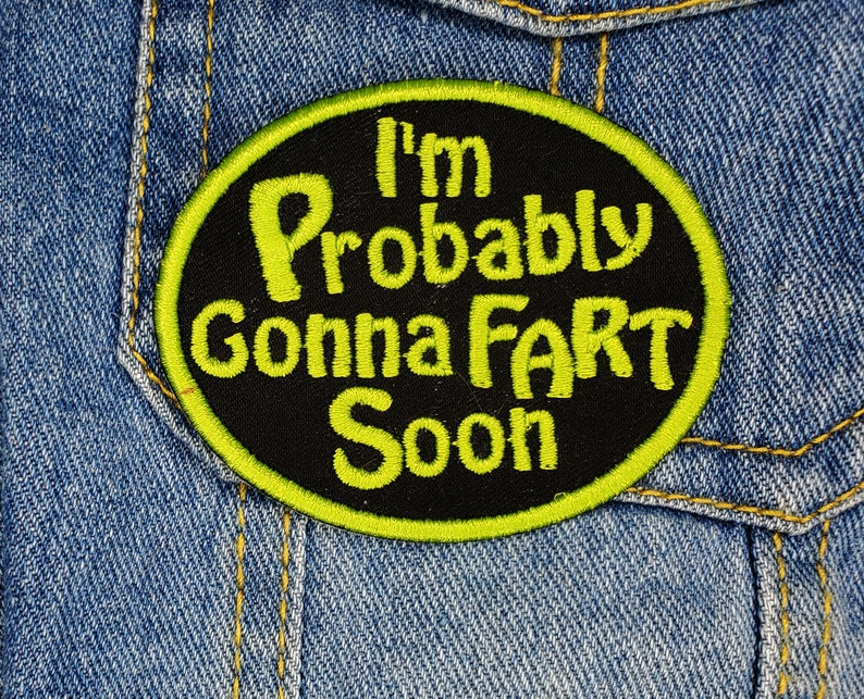 Pode incluir: Um remendo bordado preto e amarelo com o texto "I'm Probably Gonna Fart Soon".