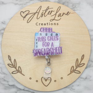 May include: Purple and white glitter badge holder with a spreadsheet themed design. The text reads "Ohhh... This calls for a spreadsheet".