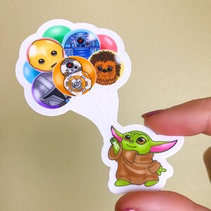 Puede incluir: Una pegatina de un personaje verde de Baby Yoda sosteniendo un mont&oacute;n de globos con personajes de Star Wars. Los globos representan a R2-D2, Chewbacca, BB-8 y un personaje amarillo con una cara triste.