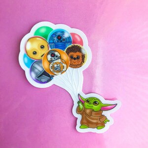 Puede incluir: Un personaje verde de Baby Yoda sosteniendo una cuerda de globos. Los globos est&aacute;n decorados con personajes de Star Wars, incluyendo R2-D2, Chewbacca y un Stormtrooper.