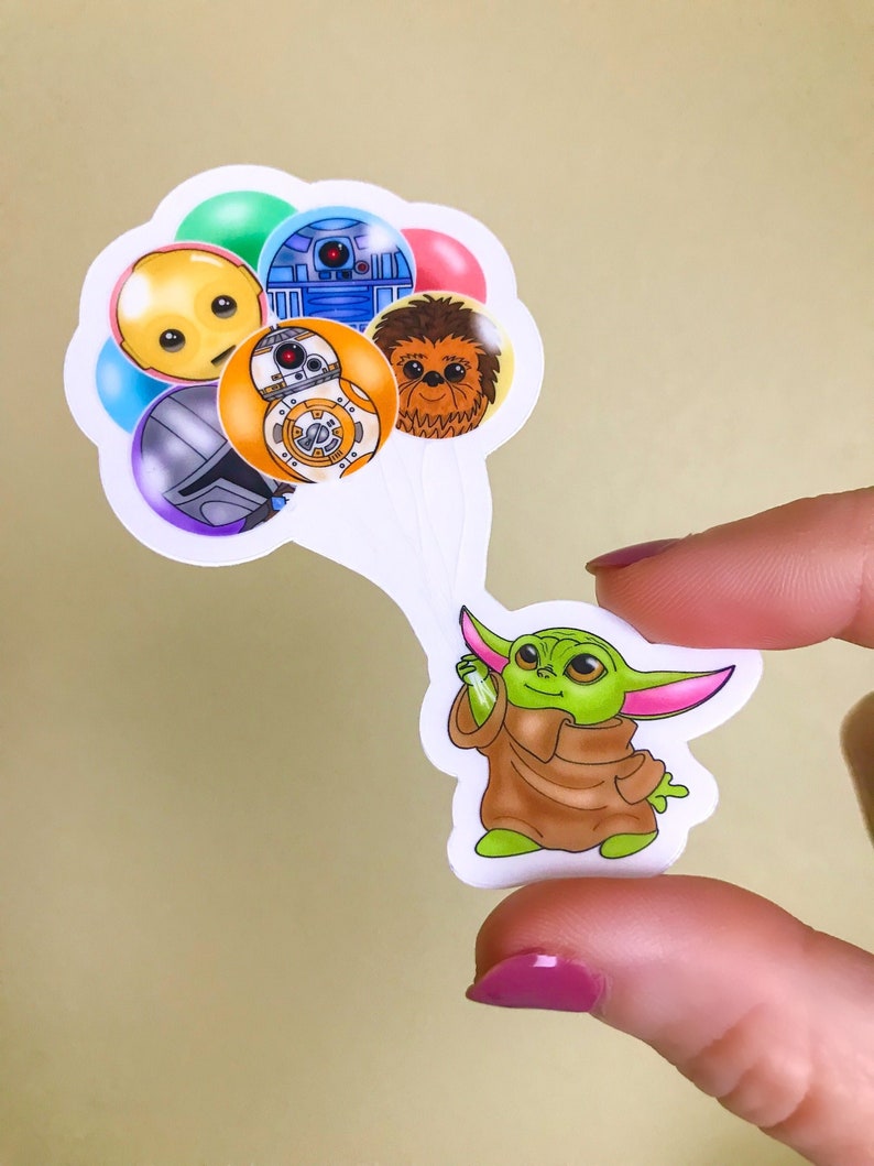 Puede incluir: Una pegatina de un personaje verde de Baby Yoda sosteniendo un mont&oacute;n de globos con personajes de Star Wars. Los globos representan a R2-D2, Chewbacca, BB-8 y un personaje amarillo con una cara triste.