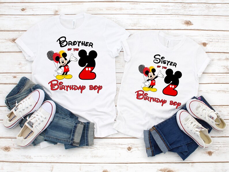 May include: Two white t-shirts featuring Mickey Mouse graphics, red and black balloons, and the text Brother of the Birthday Boy and Sister of the Birthday Boy. Each shirt displays a large number two in red and black, paired with blue jeans.
