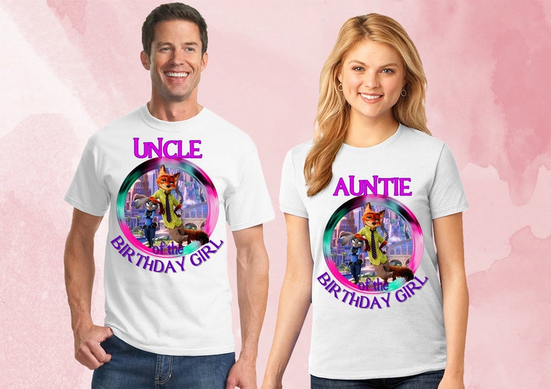 以下が含まれることがあります： ズートピアのキャラクターが描かれたカラフルなグラフィックの白いTシャツ。片方のシャツには紫色の文字で「UNCLE of the BIRTHDAY GIRL」、もう片方には「AUNTIE of the BIRTHDAY GIRL」と書かれています。男性と女性が着用しています。