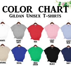 K&ouml;nnte beinhalten: Farbkarte mit Gildan Unisex-T-Shirts in verschiedenen Farben, darunter Wei&szlig;, Sportgrau, Rot, Hellrosa, Hellblau, Natur, Royal, Irish Green, Schwarz und Marine. Jedes T-Shirt wird auf einem Kleiderb&uuml;gel pr&auml;sentiert.