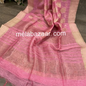 May include: A pink sheer saree with gold embroidery. The saree has a delicate, flowing texture and features a subtle shimmer. The fabric is lightweight and drapes beautifully.