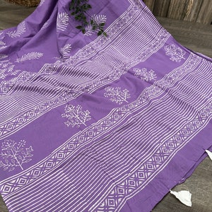 May include: A purple cotton fabric with a white block print design. The fabric features a repeating pattern of leaves and geometric shapes.