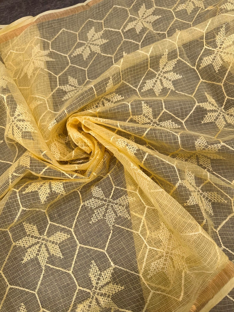 Pode incluir: Um tecido transparente amarelo claro com um delicado padr&atilde;o bordado de estrelas e um design de favo de mel.