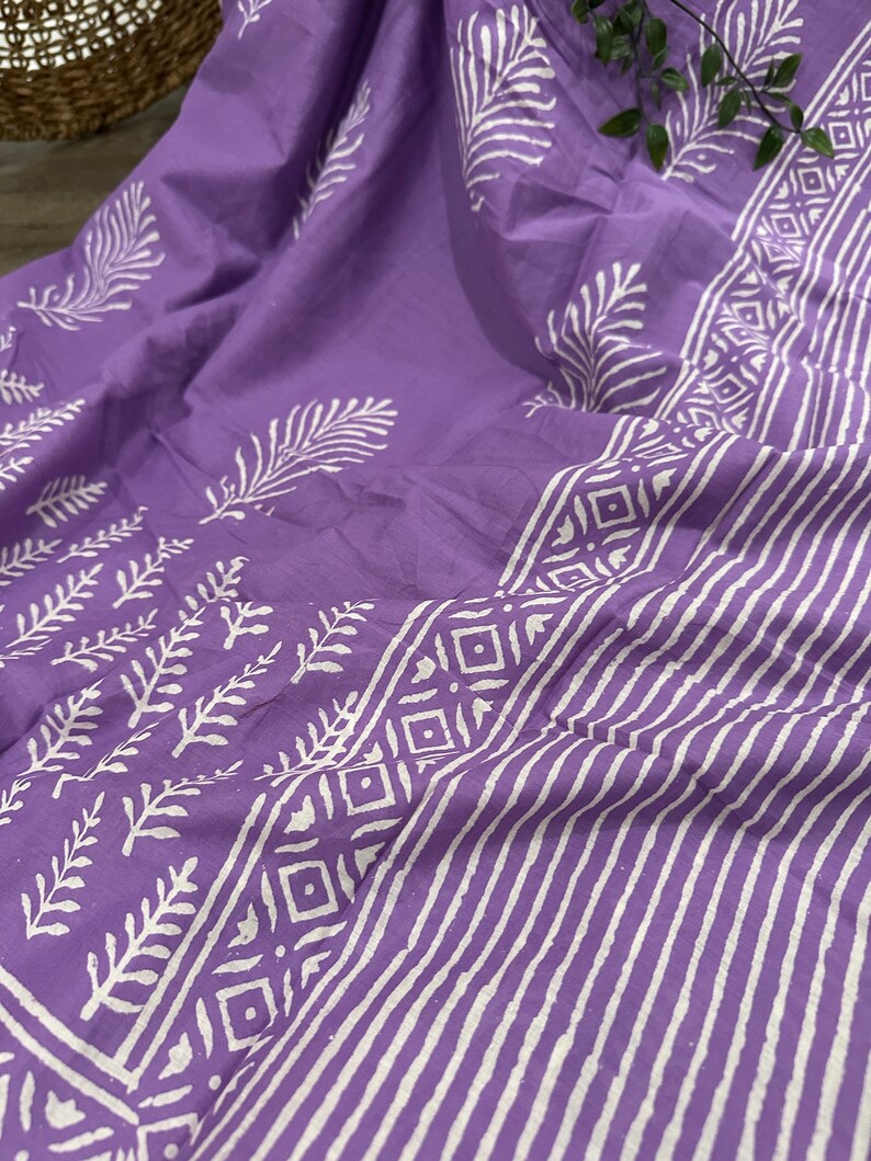 May include: Purple cotton fabric with a white block print design featuring leaves and geometric patterns. The fabric is folded and has a soft, textured feel.