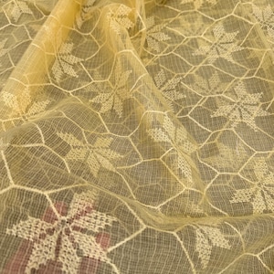 Pode incluir: Tecido transparente amarelo claro com um delicado padr&atilde;o floral branco. O tecido tem uma textura de favo de mel e &eacute; perfeito para projetos de artesanato ou costura.