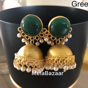May include: Gold-toned earrings with a green, circular top and a bell-shaped bottom. Small white pearls dangle from the bottom of the earrings. The earrings are displayed in front of a black background. The word "Green" is in the top right corner.