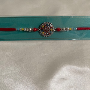 Silver circle shaped rakhi for bhai