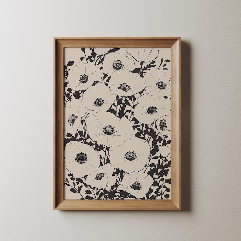 K&ouml;nnte beinhalten: Ein gerahmter Schwarzwei&szlig;druck mit einem floralen Design, das eine Ansammlung von Mohnblumen zeigt. Die Blumen sind in Schwarz auf einem cremefarbenen Hintergrund umrandet.