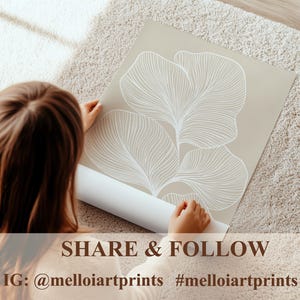 Puede incluir: Una impresi&oacute;n beige con un dise&ntilde;o abstracto blanco de hojas. La impresi&oacute;n est&aacute; siendo sostenida por una persona. El texto en la impresi&oacute;n dice "SHARE & FOLLOW IG: @melloiartprints #melloiartprints".