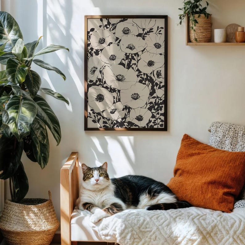 K&ouml;nnte beinhalten: Eine Schwarzwei&szlig;illustration eines B&uuml;schels Mohnblumen in voller Bl&uuml;te. Der Druck ist gerahmt und h&auml;ngt an einer Wand in einem Wohnzimmer.
