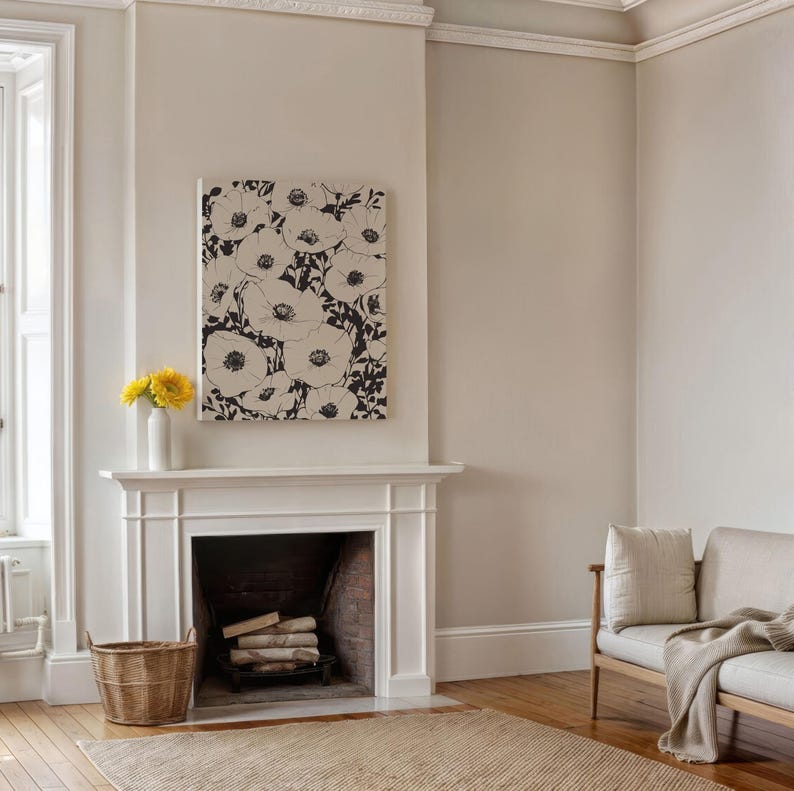 K&ouml;nnte beinhalten: Ein wei&szlig;er Kaminsims mit einem schwarz-wei&szlig;en floralen Leinwandbild dar&uuml;ber. Der Kamin hat einen Backstein-Innenraum und ein Holzfeuer. Ein Weidenkorb steht auf dem Boden vor dem Kamin.