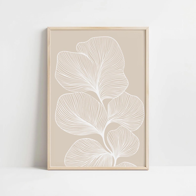 Puede incluir: Una impresi&oacute;n enmarcada beige con un dibujo de l&iacute;nea blanca de una planta estilizada con hojas. Las hojas est&aacute;n dispuestas en un patr&oacute;n vertical.