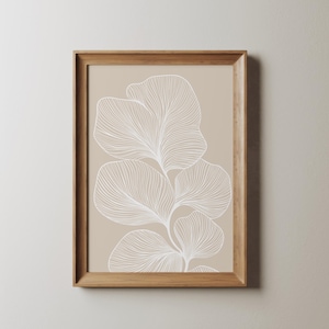 Puede incluir: Una impresi&oacute;n enmarcada con un fondo beige y un dibujo de l&iacute;nea blanca de una planta estilizada con hojas.