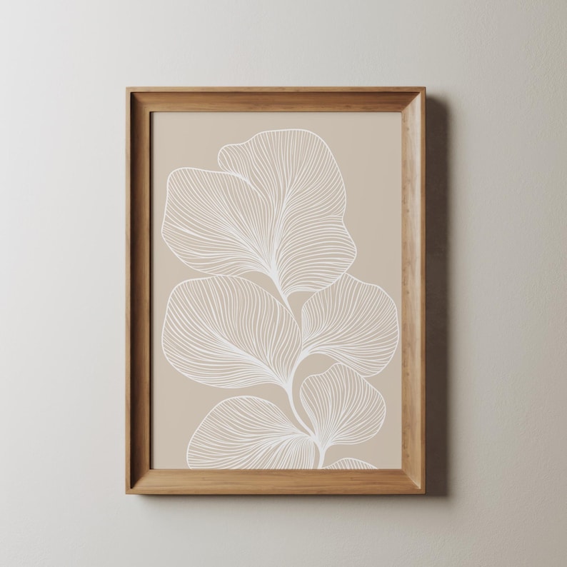 Puede incluir: Una impresi&oacute;n enmarcada con un fondo beige y un dibujo de l&iacute;nea blanca de una planta estilizada con hojas.