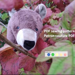 Peut inclure: Patron de couture PDF pour un ours en peluche brun avec un museau blanc et un nez noir. Le patron est intitulé "Patron de couture PDF" et "Patron couture PDF". Le niveau de difficulté est indiqué par un cercle bleu, un cercle vert, un cercle jaune et un cercle orange.
