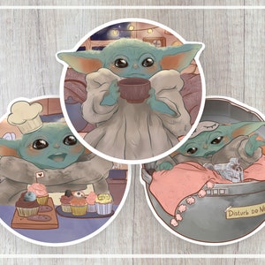 Puede incluir: Tres pegatinas ilustradas con un personaje alienígena verde en diferentes poses. La primera pegatina muestra al alienígena con un gorro de cocinero y sosteniendo un plato de cupcakes. La segunda pegatina muestra al alienígena con una bata y sosteniendo una taza. La tercera pegatina muestra al alienígena durmiendo en un contenedor de metal con el texto "Disturb Do Not!" en el lateral.