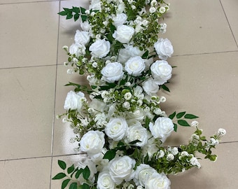 May include: A long garland of white roses and greenery. The garland is made of artificial flowers and is perfect for a wedding or other special event.