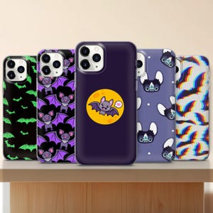 May include: Five different phone cases with a Halloween theme. The cases feature bats, a moon, and a rainbow pattern.