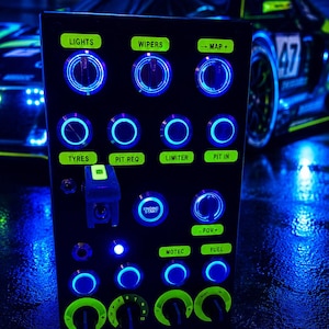 May include: A black rectangular button box for racing simulation featuring multiple rotary dials and push buttons illuminated by blue LED rings. The panel includes neon green labels for functions like LIGHTS, WIPERS, MAP, TYRES, PIT REQ, LIMITER, PIT IN, ENGINE START, FOV, MOTEC, and FUEL.