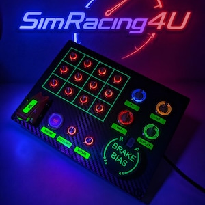 May include: A black carbon fiber sim racing button box featuring a grid of red illuminated buttons, a large green brake bias dial, and various toggle switches labeled engine, cycle lights, wipers, map, tc, abs, and display, with a neon logo above.