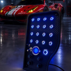 May include: A black carbon fibre control panel featuring a grid of illuminated blue push buttons, two metal toggle switches, a central blue Engine Start button, and three rotary knobs at the bottom, all emitting a bright blue glow.