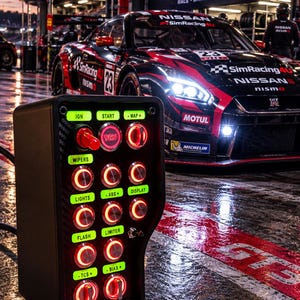 May include: A black button box controller featuring multiple illuminated red push buttons and toggle switches with green labels including IGN, START, MAP, WIPERS, LIGHTS, ABS, DISPLAY, FLASH, LIMITER, TCS, and BIAS, set against a race car background.