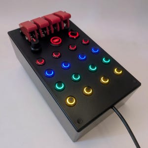 May include: A black box with a variety of colored buttons and four red toggle switches. The box is labeled "Start".