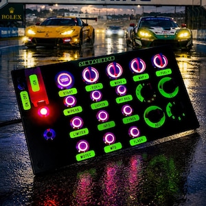 Op de afbeelding: Een zwarte rechthoekige sim-racing knoppenbox met verlichte groene labels en roze omrande draaiknoppen. Het apparaat is voorzien van een rode tuimelschakelaar voor ontsteking en diverse bedieningselementen met de labels Start, Wipers, Limiter, Motec, Fov, Lights, Info, Mfd, Menu, Pit Req, Tyres, Flash, Map, Fuel, Tc en Abs.