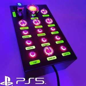 Op de afbeelding: Een zwart bedieningspaneel met een verscheidenheid aan knoppen en schakelaars. De knoppen zijn verlicht in roze en groen. Het paneel is gelabeld met de woorden "ON/OFF", "LIMITER", "DISPLAY", "TIME", "PASS RIGHT", "PASS LEFT", "WIPERS", "LIGHTS", "ABS+", "MAP+", "TC1", "RAIN", "FLASH", "ENGINE" en "BIAS".