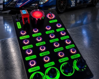 Op de afbeelding: Een zwarte knoppenpaneel voor racesimulatoren met verlichte rode drukknoppen en groene labels. Voorzien van een motorstartknop, tuimelschakelaars en draaiknoppen met de aanduidingen ABS, TC, BIAS en diverse autofuncties zoals PIT, WIPERS en LIGHTS.