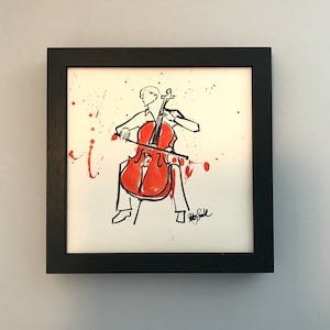 May include: A black framed drawing of a person playing a cello. The drawing is done in black ink with red watercolour accents. The person is wearing a white shirt and black trousers. The cello is red and has a black bow. The drawing is signed "Roy Stile" in the bottom right corner.
