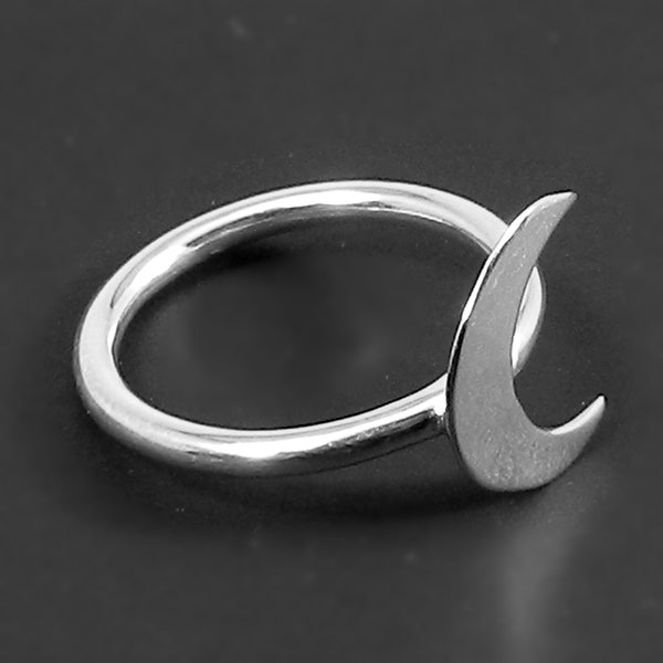May include: A silver-colored ring featuring a crescent moon design. The ring has a smooth, polished finish and a minimalist aesthetic. The moon shape is slightly curved, adding a touch of celestial charm to the jewelry.