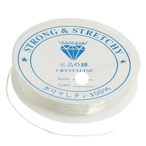 May include: A spool of clear elastic string for jewellery making. The label reads "Strong & Stretchy" and "Crystaline" in English and Japanese. The label also says "Polyurethane 100%".