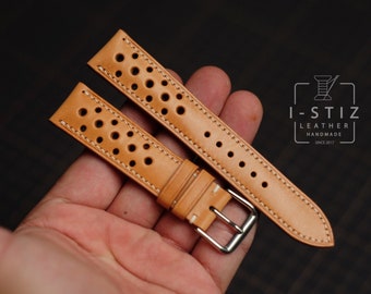 May include: Two tan leather watch straps with white stitching and a perforated design. The straps are laid out on a hand, showing the buckle and the holes.