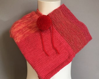 A Lovely Handmade Knitted Soft Baby Poncho in Different Red and Orange tones.