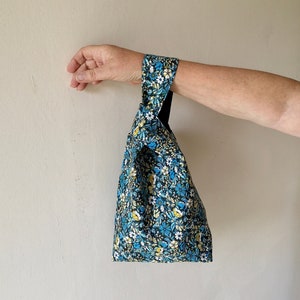 A beautiful and luxurious Japanese Knot Bag in 100% Blue Cotton with lighter Blue, Yellow and White Flowers. Lined with Cotton.